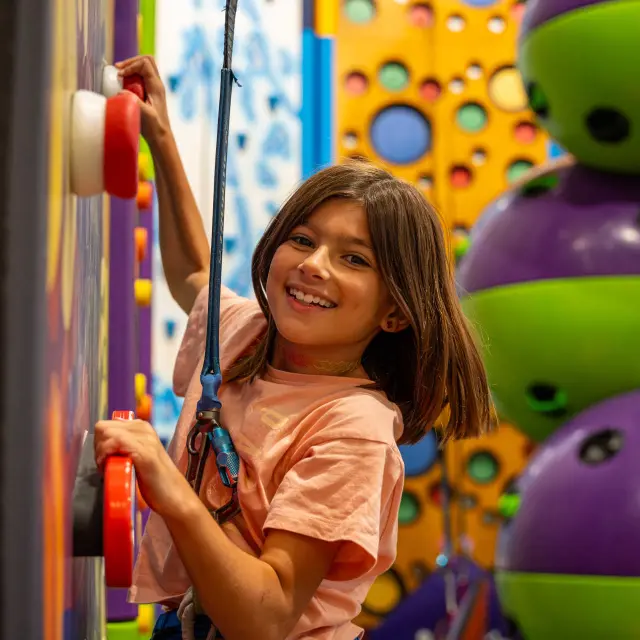 Une petite fille s'amuse à grimper au Pôle Sport Innovation des Orres