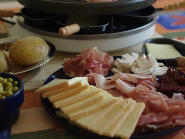 Gros plan sur un plateau de raclette et charcuterie