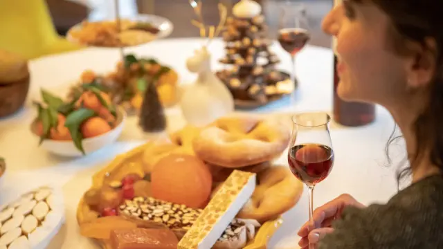 Woman seated at a table in front of a Christmas meal
