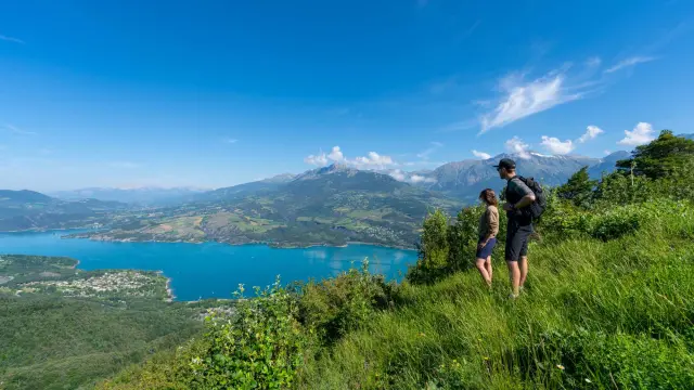 Couple en randonnée avec vue sur le lac de Serre-Ponçon