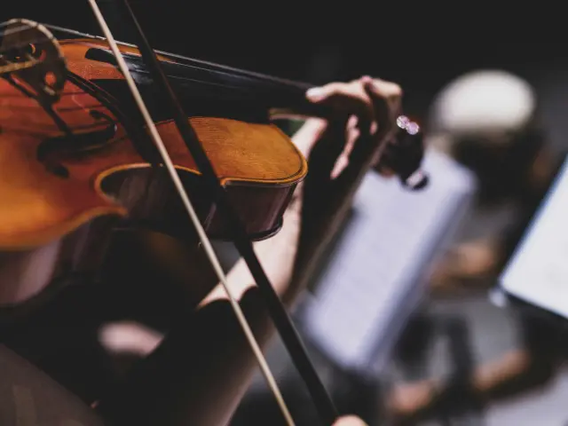 Eine Frau, die in einem Orchester Geige spielt
